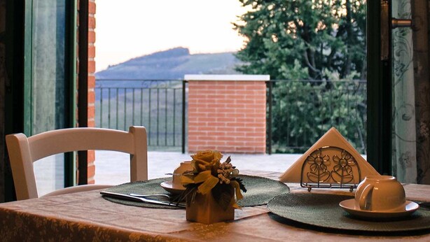 A table set for two with a vase of flowers, a teapot, and a tray with a teacup. - B&B Corte Galo (Tregnago)