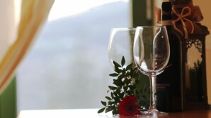 Two empty wine glasses, a bottle of wine, a red rose, and a gift box on a table. - B&B Corte Galo (Tregnago)