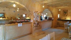 A rustic interior with stone walls, wooden furniture, and a bar area with a counter. - Agroturismo Finca Son Sureda (Manacor)