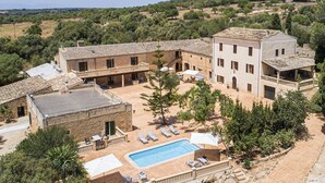 A villa with a swimming pool, outdoor seating, and a courtyard surrounded by trees. - Agroturismo Finca Son Sureda (Manacor)