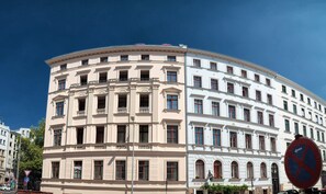 Ein mehrstöckiges Gebäude mit klassischer Architektur, das eine geschwungene Fassade und zahlreiche Fenster aufweist.