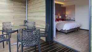 Una habitación moderna con una cama, una mesita y sillas.
