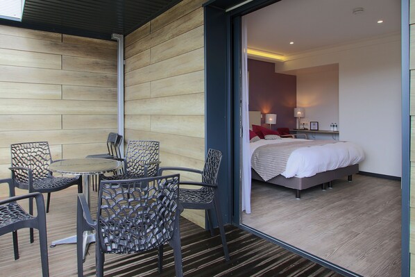 A modern room with a bed, a small table, and chairs.
