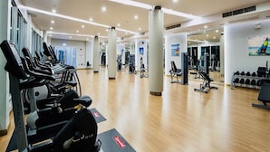 A spacious gym with cardio machines, free weights, and mirrors on the walls. - Supalai Mare Pattaya Condo Sea View by Dome (Pattaya)