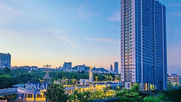 A tall, modern high-rise building with a grid-like facade, surrounded by greenery and other buildings. - Supalai Mare Pattaya Condo Sea View by Dome (Pattaya)
