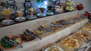 A buffet table with various food items and serving utensils. - Orzu Hotel (Tashkent)