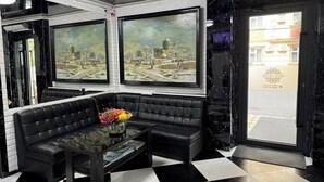 A lobby with a black and white checkered floor, a black leather sofa, and two large framed paintings on the walls. - Orzu Hotel (Tashkent)