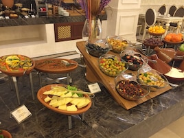Buffet-pöydässä on tarjolla monipuolinen valikoima ruokia, kuten salaatteja, hedelmiä ja vihanneksia.