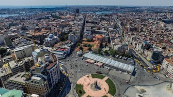 An aerial view of a cityscape with a prominent square, surrounding buildings, and a river in the background.