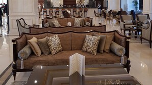 A luxurious lobby with a grand chandelier, a plush brown sofa, and a reflective floor. - Ottoman's Life Hotel Deluxe (Istanbul)