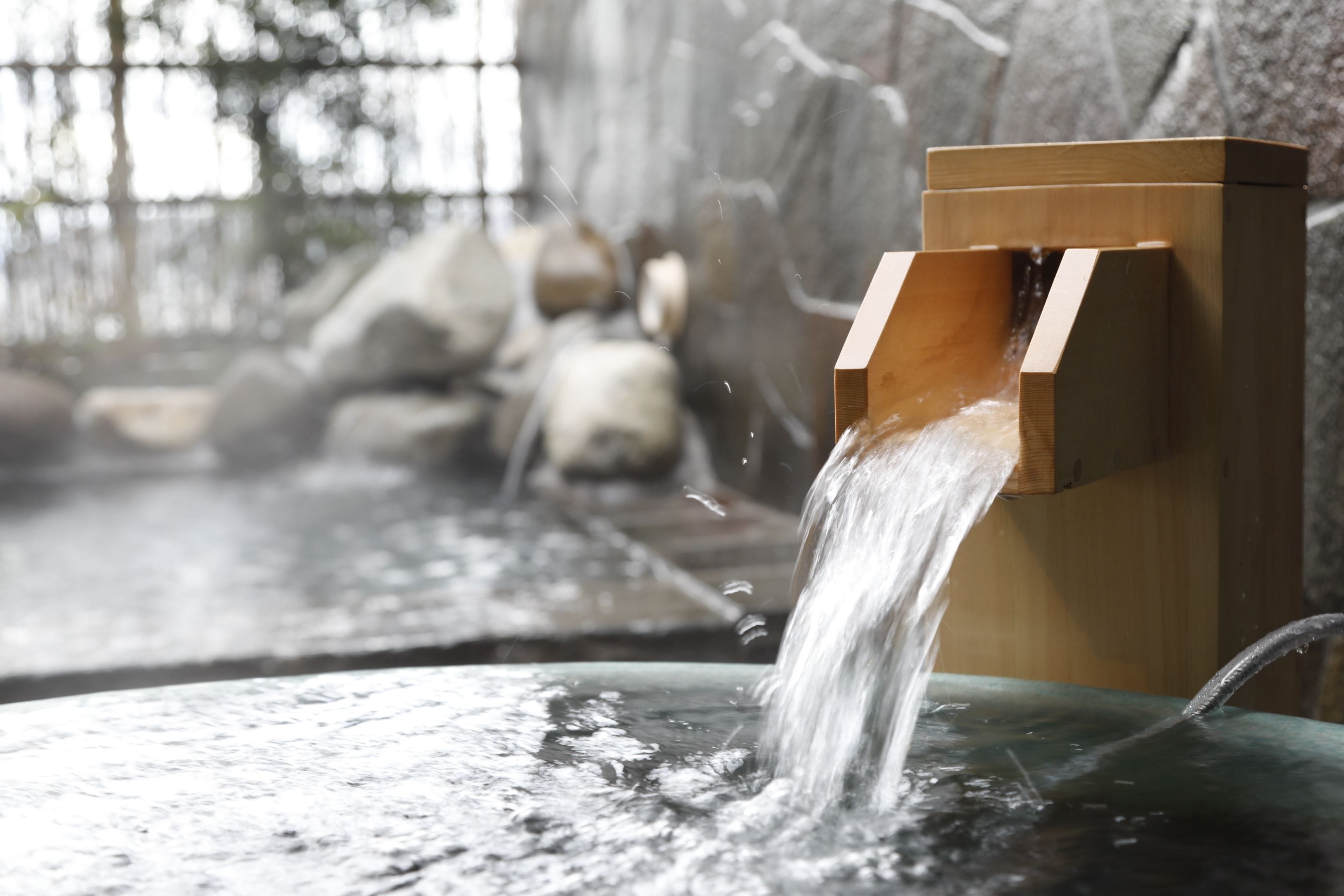 Una fuente de madera con agua fluyendo hacia una cuenca.