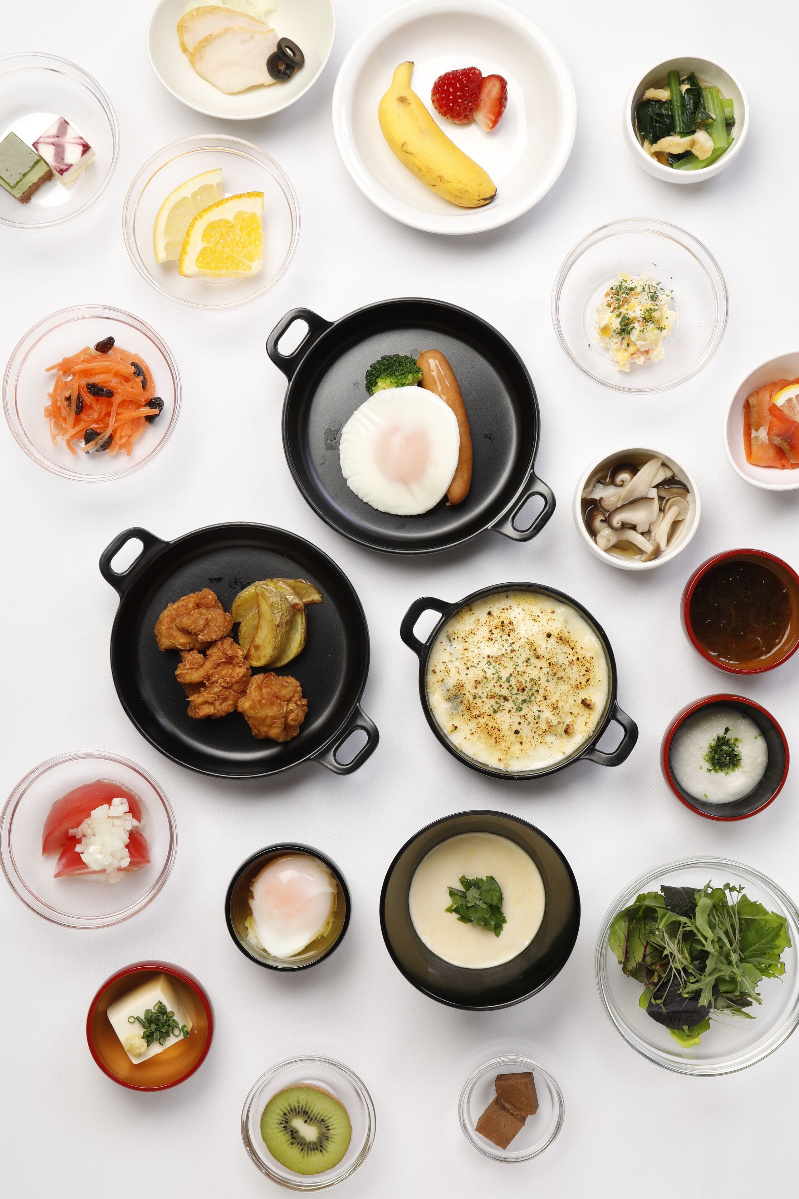 A variety of dishes including sushi, a poached egg, and a bowl of soup.