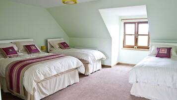 A bedroom with two beds, a window, and a yellow light fixture.