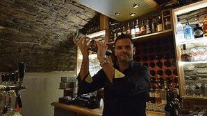 A bar with a stone wall and shelves of bottles. - Hotel Rosenhaus Garni (Velbert)