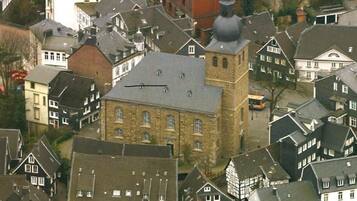 A historic building with a prominent tower, surrounded by traditional European-style houses.