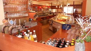 A bar area with multiple beverage dispensers, shelves with glasses, and a variety of bottles. - Pension Einsiedl (Ottenschlag)