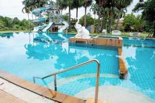 Una piscina al aire libre, sillones reclinables de piscina