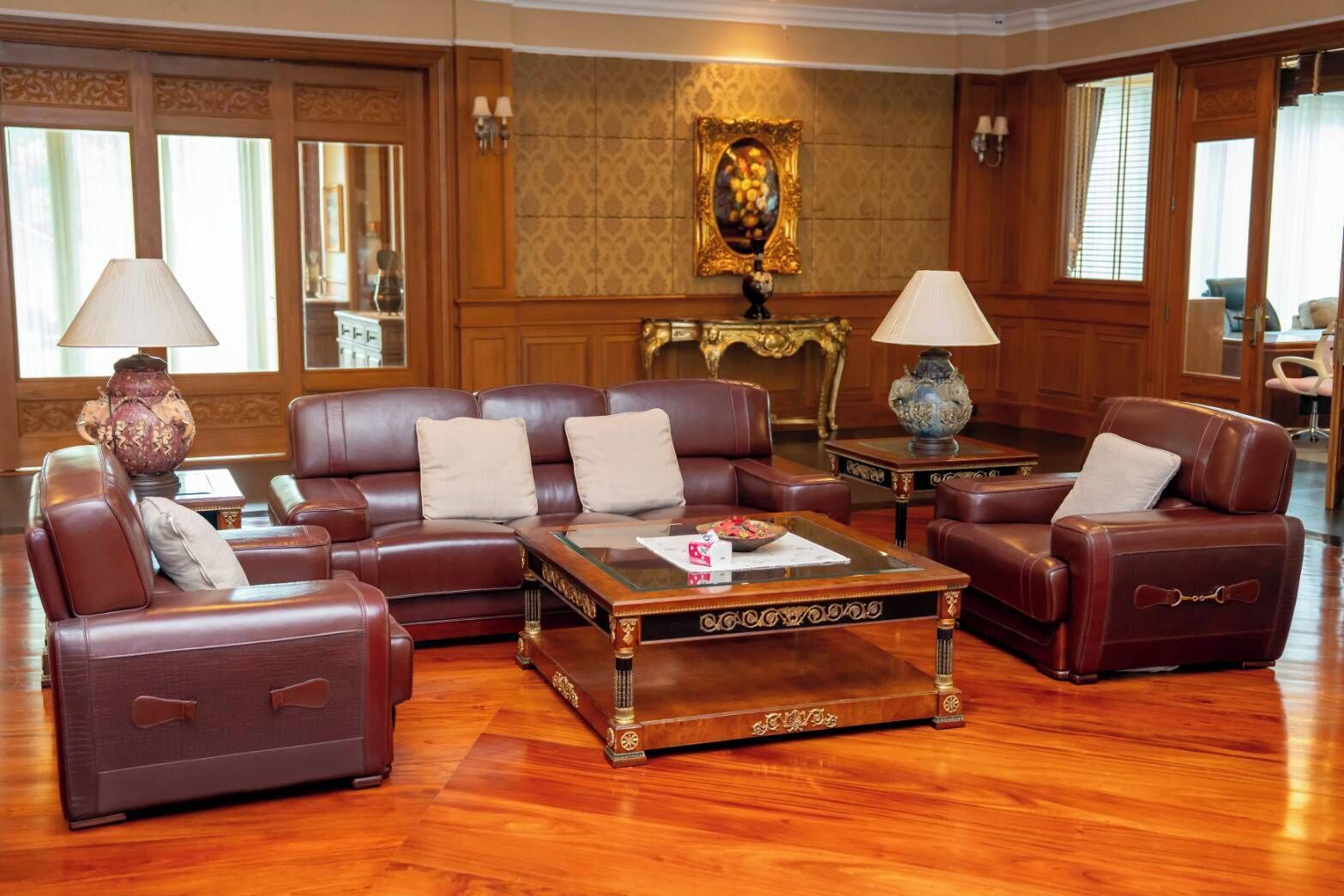A traditional room with leather sofas, a wooden coffee table, and a decorative lamp.