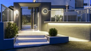 A modern multi-story building with a prominent entrance, a visible logo, and a well-lit facade. - Serenity Suites (Nikiti)
