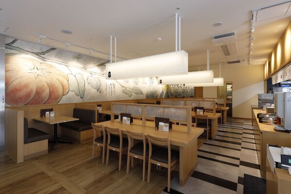 A restaurant with wooden furniture, a mural of pumpkins, and a modern kitchen area. - Sotetsu Fresa Inn Kobe Sannomiya (Kobe)