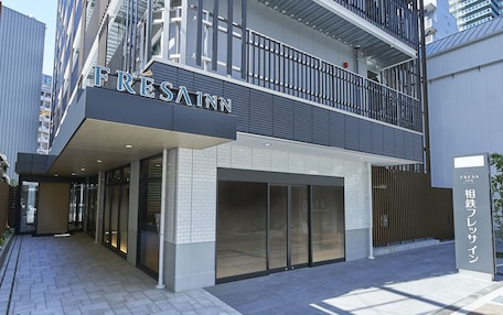 A modern hotel entrance with a prominent sign reading "FRESSAINN".