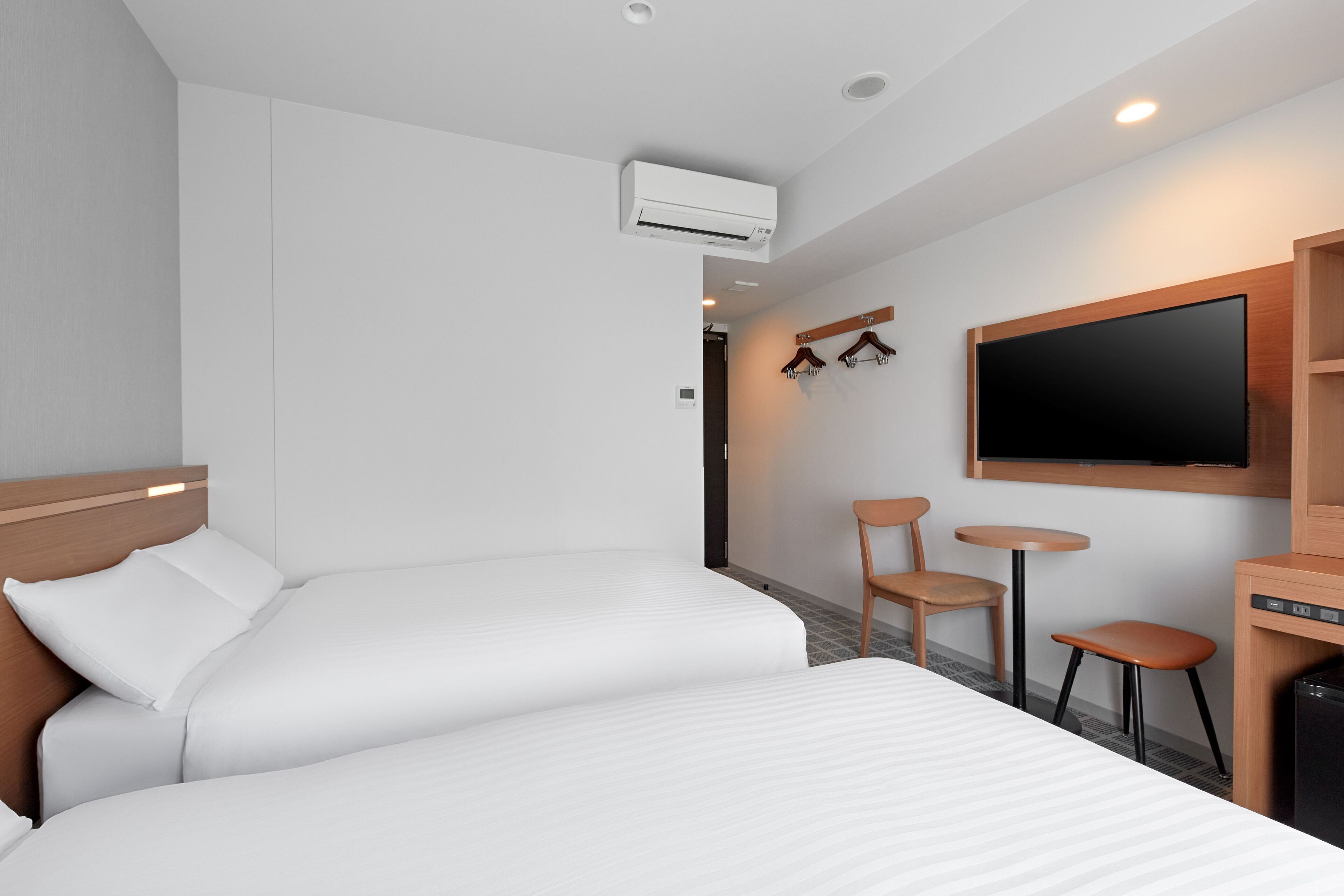 Une chambre d’hôtel avec un lit, une télévision, un bureau et une chaise.