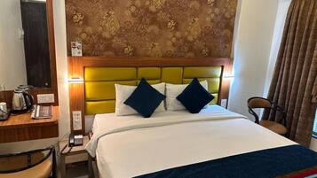 A hotel room with a bed, a desk with a telephone, and a chair.