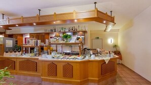 A buffet setup with a variety of food items and beverages, a wooden counter, and a decorative ceiling. - Montana Senden M ünster (Senden)
