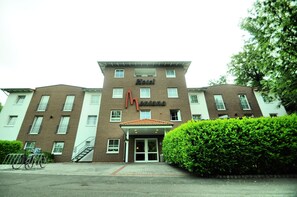 A hotel with a brick facade, a sign reading "Hotel Montana," and a covered entrance. - (Senden)