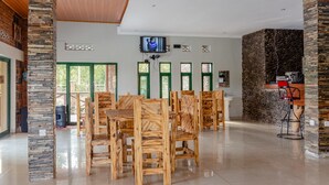 Uma ampla sala de jantar com móveis de madeira e um pilar de pedra.