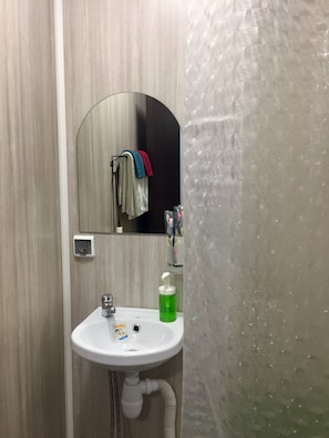 Bathroom features a sink, mirror, shower area, and towel rack.