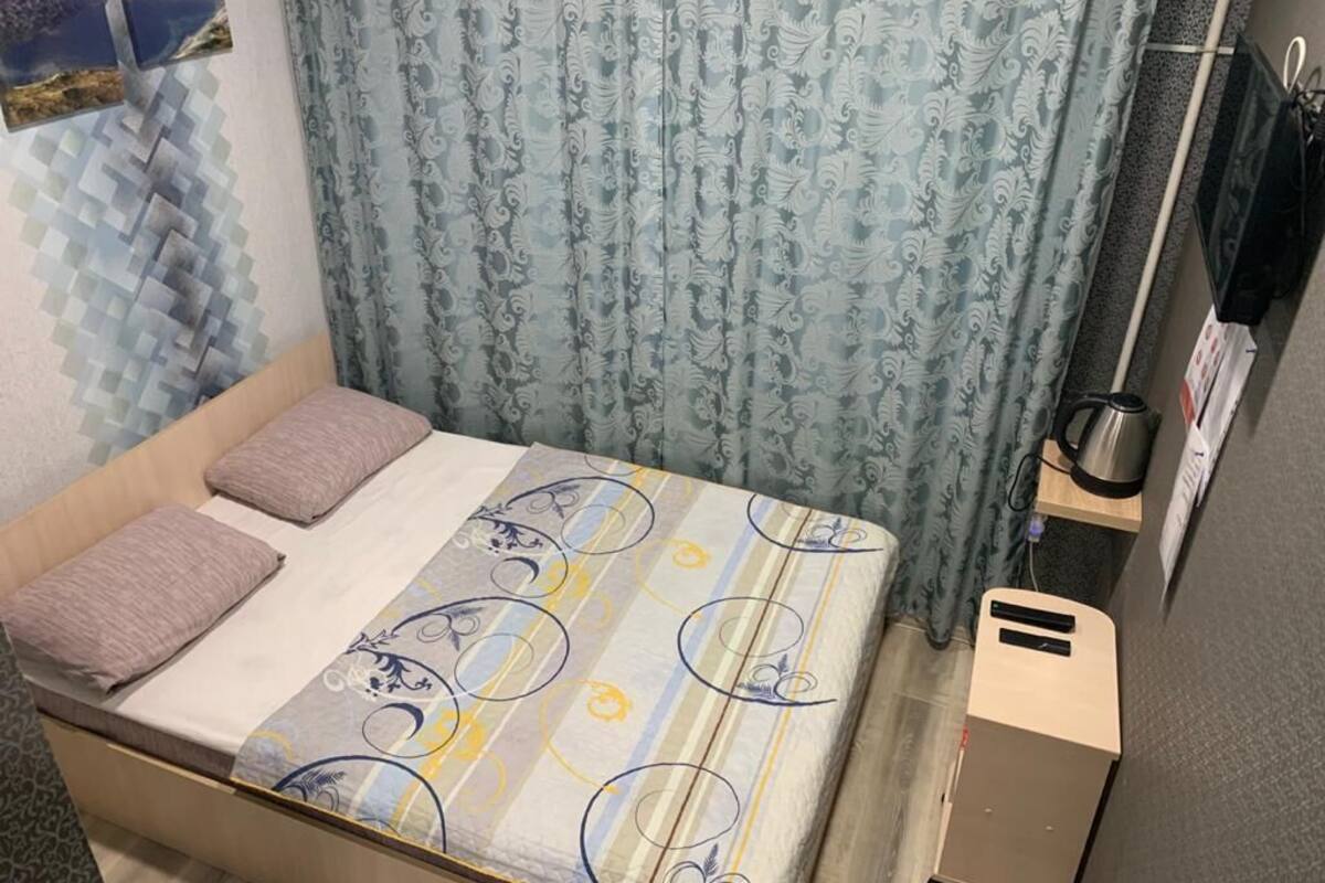 Simple, functional room with a bed, nightstand, and modern amenities.