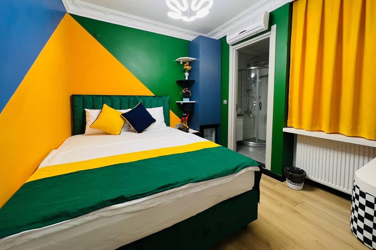A modern hotel room with a bed, a shower, and a view of the outside.