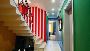 A staircase with red and white striped walls, a green wall on the right, and a door at the end. - Apex Hotel (Istanbul)