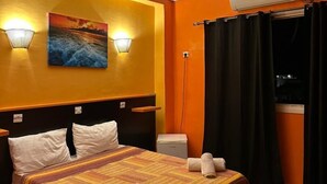 A hotel room with a bed, a painting, an air conditioner, and a window with curtains. - Hôtel La Brise (Ain El Turk)