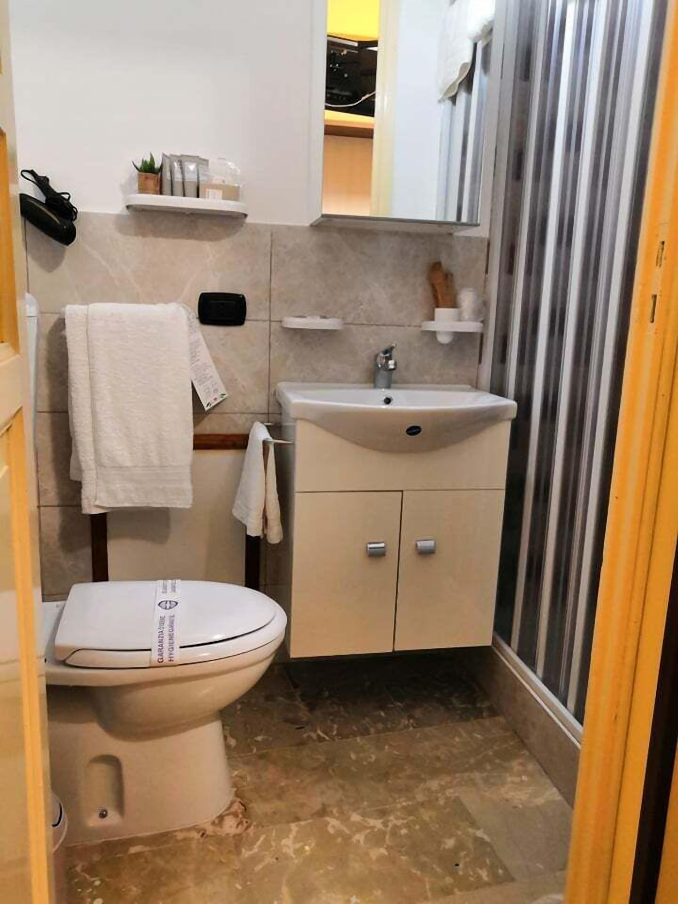 A compact bathroom with a toilet, sink, and storage cabinets.
