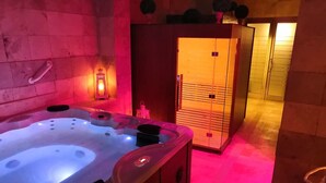 Een wellnessruimte met een bubbelbad, een kast en een deur.