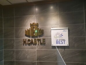 Une enseigne portant l’inscription « H. CASTLE » et un logo représentant un château.