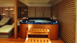 A spa room with a hot tub, wooden benches, and a massage table. - Hotel Tarsis Club - All Inclusive (Sunny Beach)