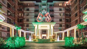 A multi-story hotel with a central atrium, balconies, and a decorative fountain. - Hotel Tarsis Club - All Inclusive (Sunny Beach)