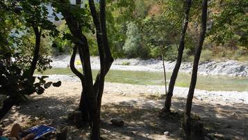 A campsite with tents, trees, and a river.