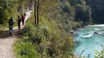 Un sentier de gravier longeant une rivière, avec des randonneurs.