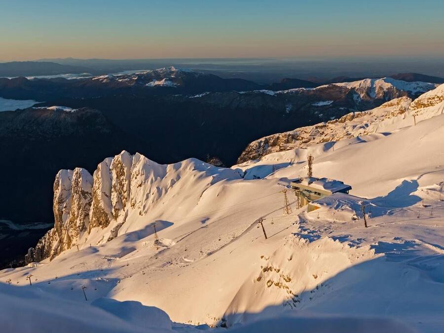 Une montagne enneigée, dotée de remontées mécaniques, offrant une vue dégagée sur les sommets lointains.