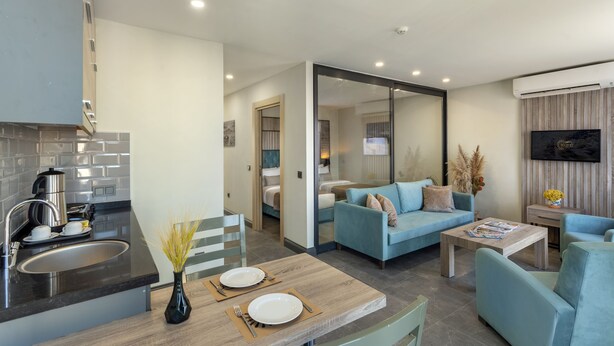 Eine moderne Küche mit Spüle, Herd und Essbereich. Ein Wohnzimmer mit Sofa und Couchtisch.