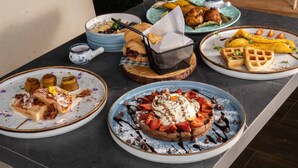 A table with various breakfast dishes including waffles, pancakes, and croissants. - Hotel Plaza Del Lili (Cali)