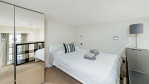 Une chambre d’hôtel avec un lit, un bureau et un miroir.