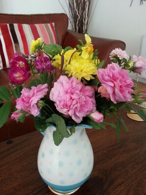 A vase with a floral arrangement on a wooden table.