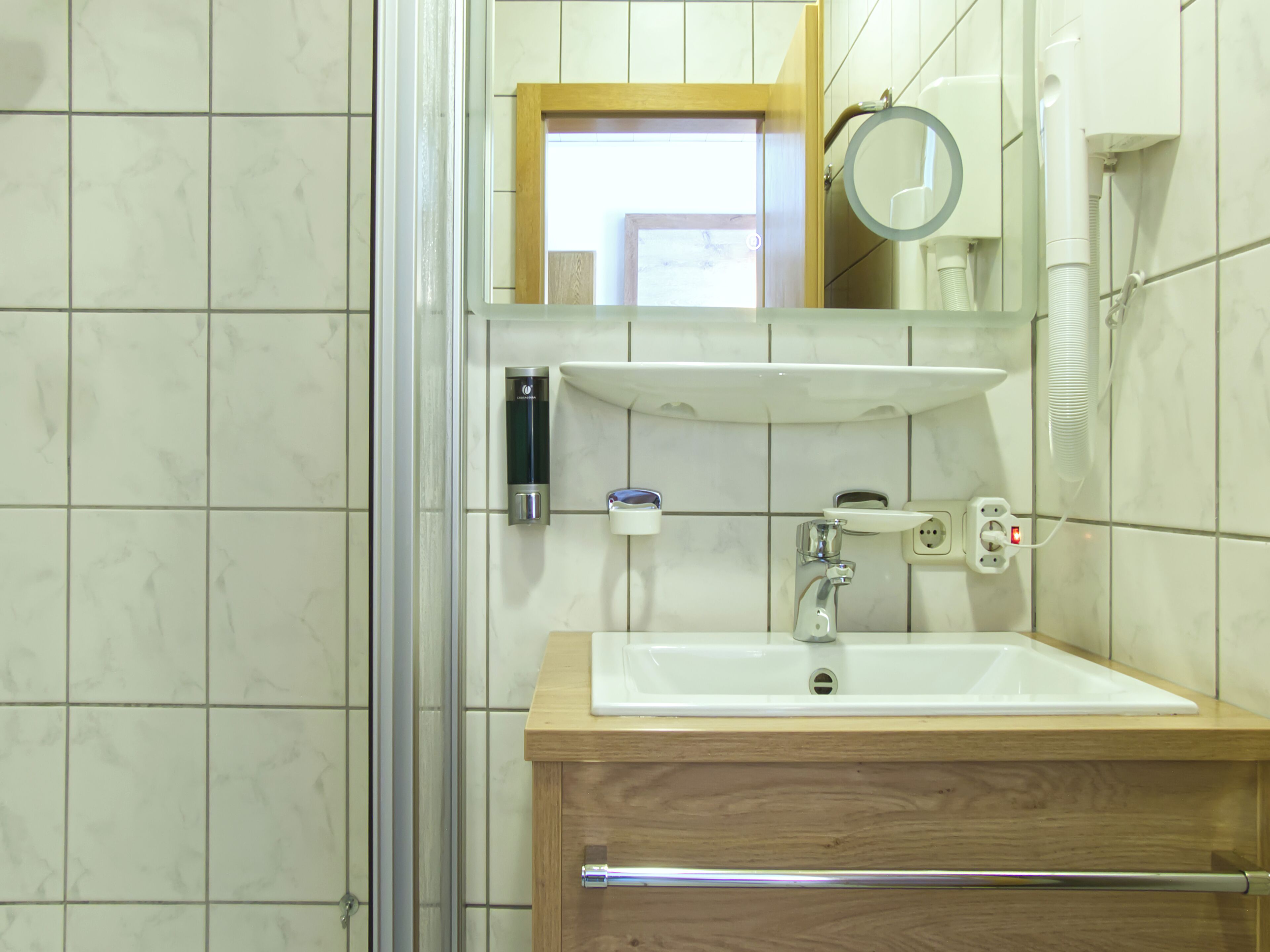 A bathroom with a sink, mirror, and towel rack.