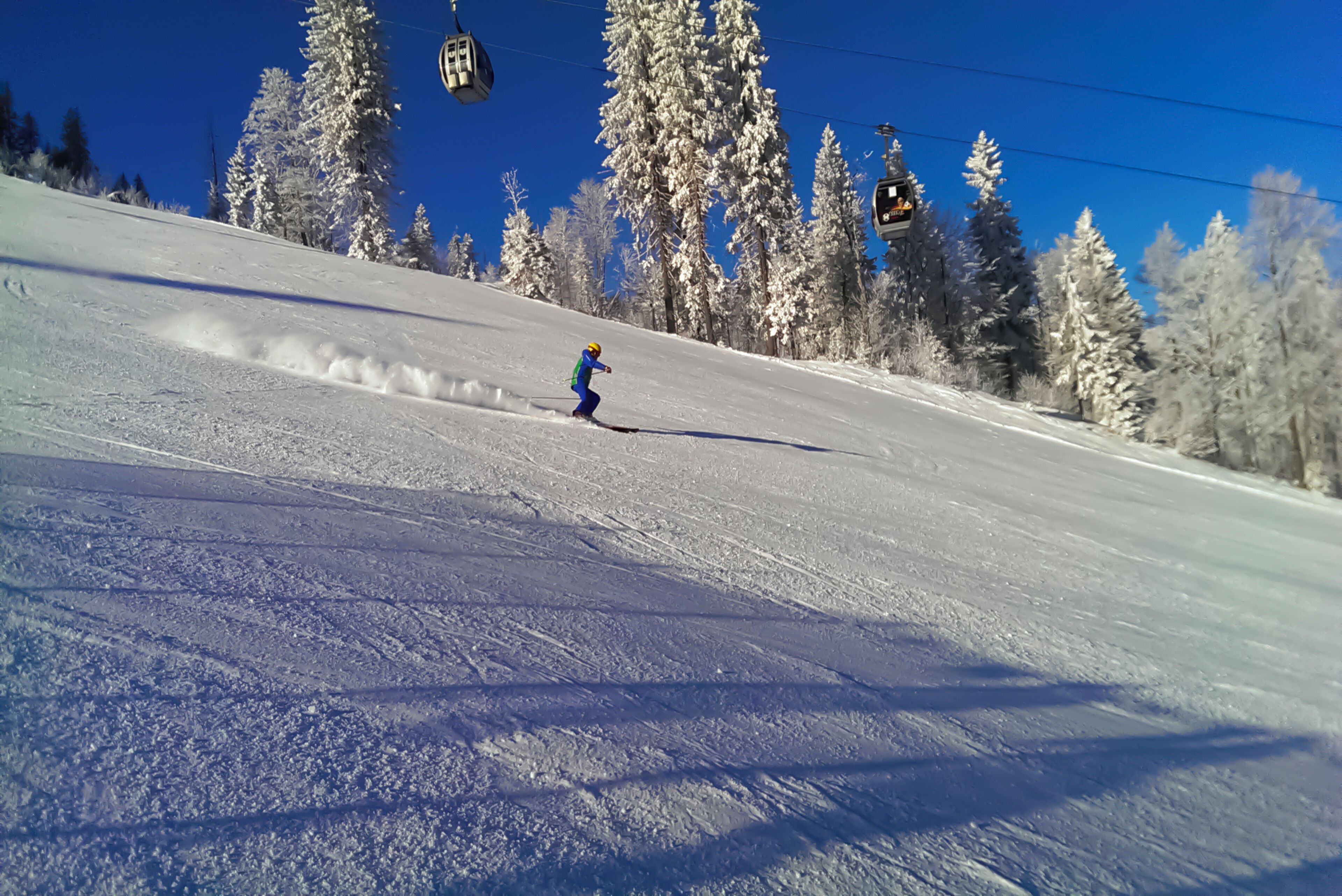 A snowy ski slope with a skier.