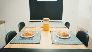 A dining table with two plates of croissants, a glass of water, and a jug of orange juice. - Apartments Franky6 (Zagreb)